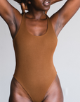 model showing front view of ella nude, brown, bodysuit.  Scoop style, thong bottom.