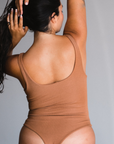 Back view of bodysuit, thong style. Maya nude color, a caramel tone.